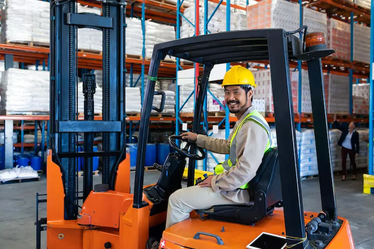 trabajador masculino sentado carretilla elevadora mirando camara almacen 13339 358580